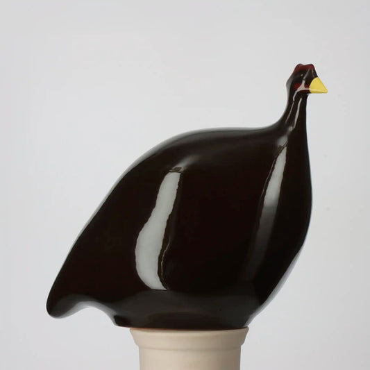 Les Céramiques de Lussan large solid black ceramic guinea fowl figurine with white breast and yellow beak.