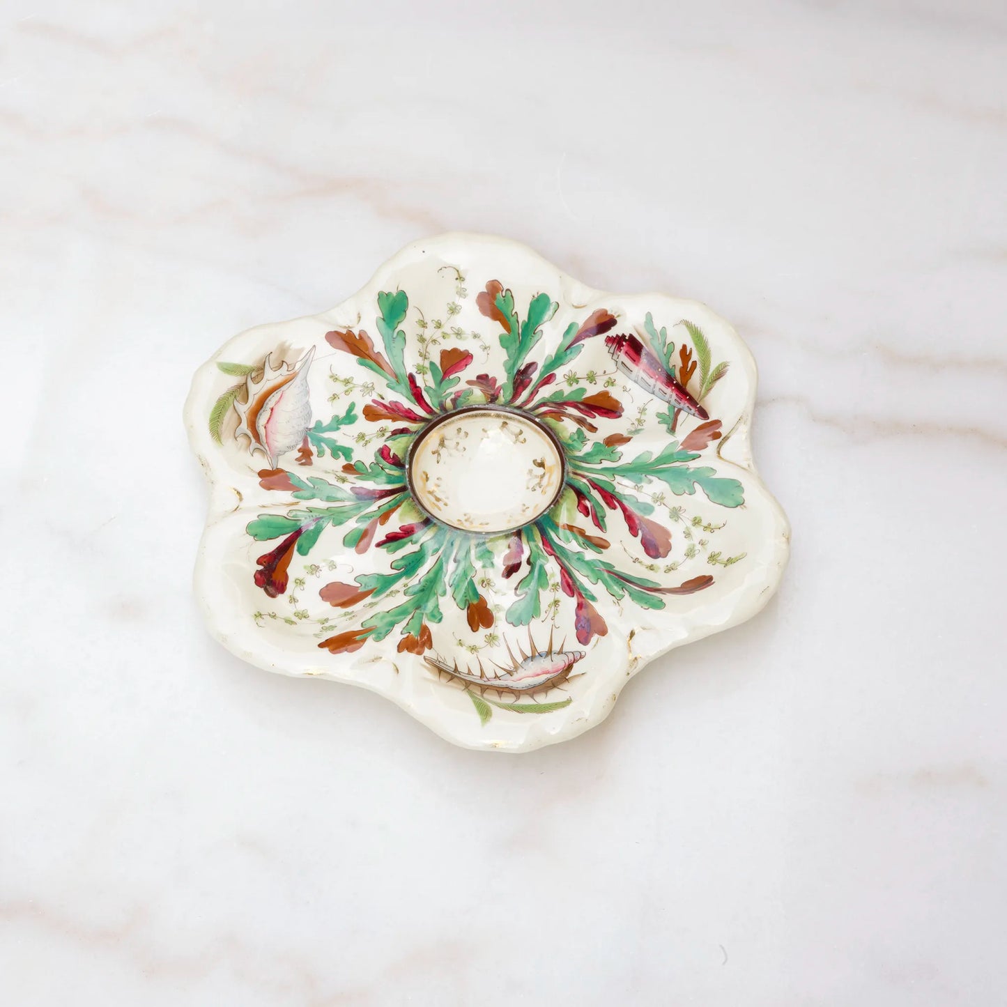 Limoges oyster plate decorated with painted shells and seaweed