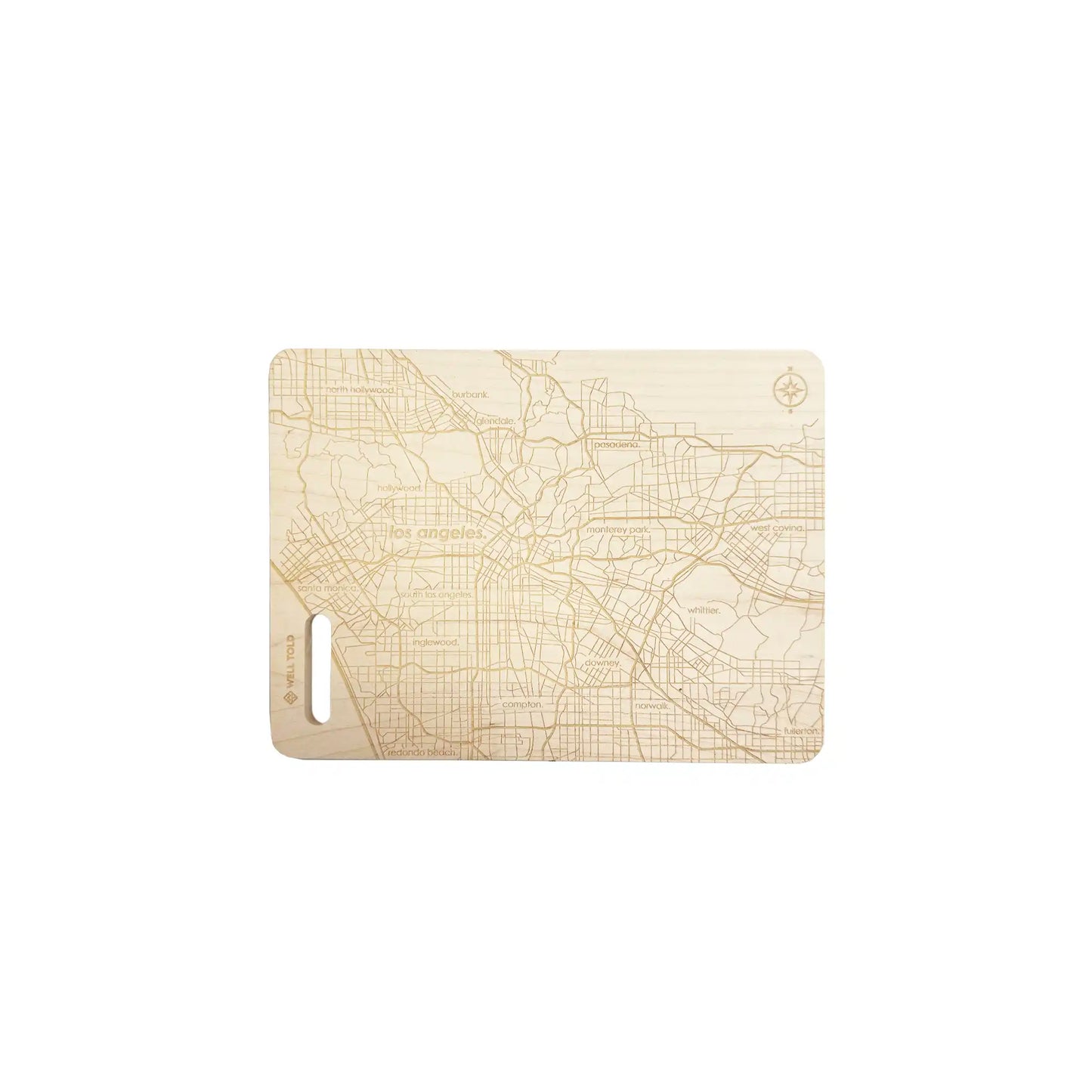 Well Told Los Angeles map engraved wooden cutting board with detailed city street grid design and handle cutout.
